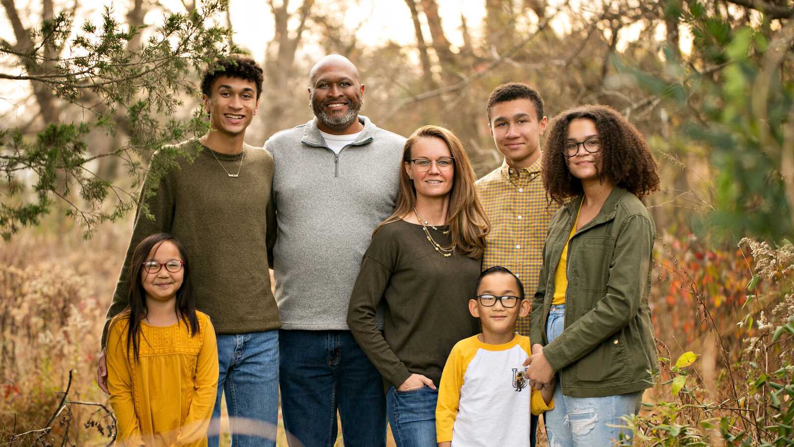 adopted family smiling outside woods