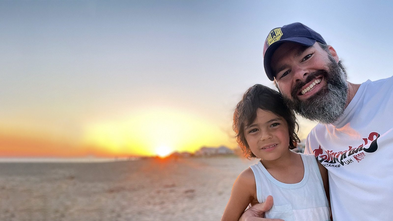 Adoptive dad and son adopted from Colombia at sunset on the beach.