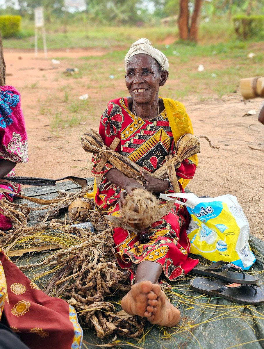 Older caregiver makes toys from found objects at the Wakivule School on National Play Day in Uganda