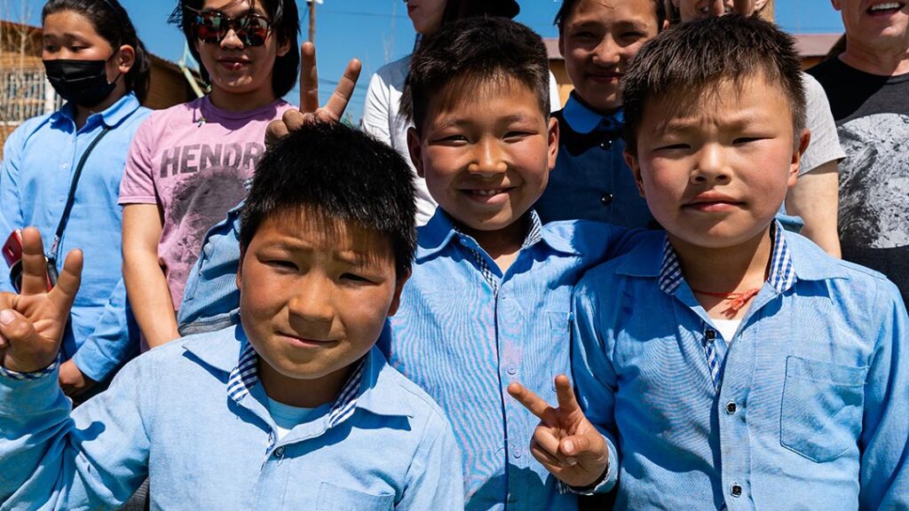 boys smile and give peace signs for camera