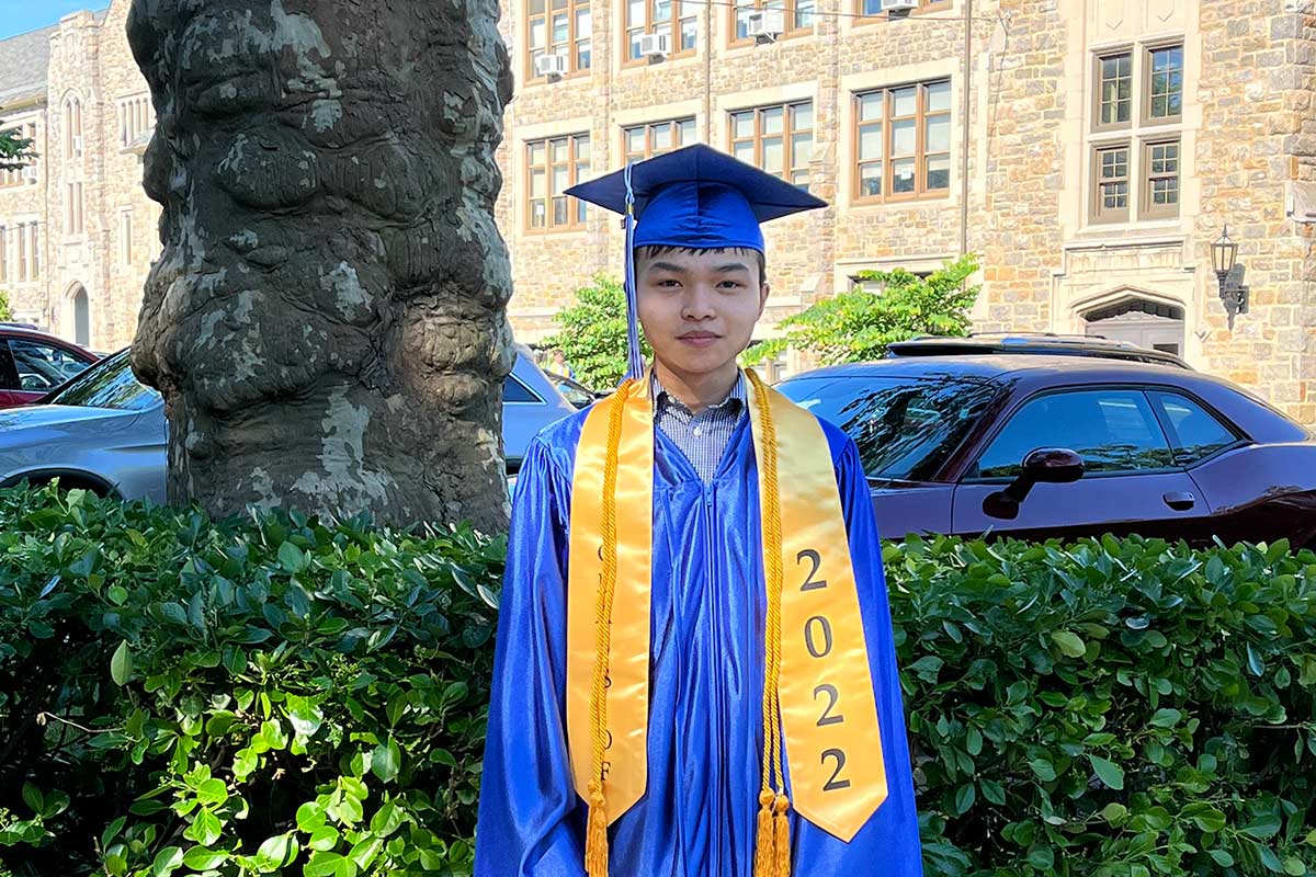 Vietnamese adoptee in graduation cap and gown, being adopted
