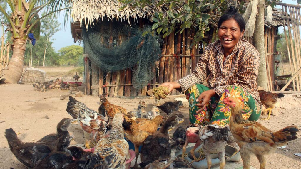 Mom feeding her chickens with a big joyous smile on her face