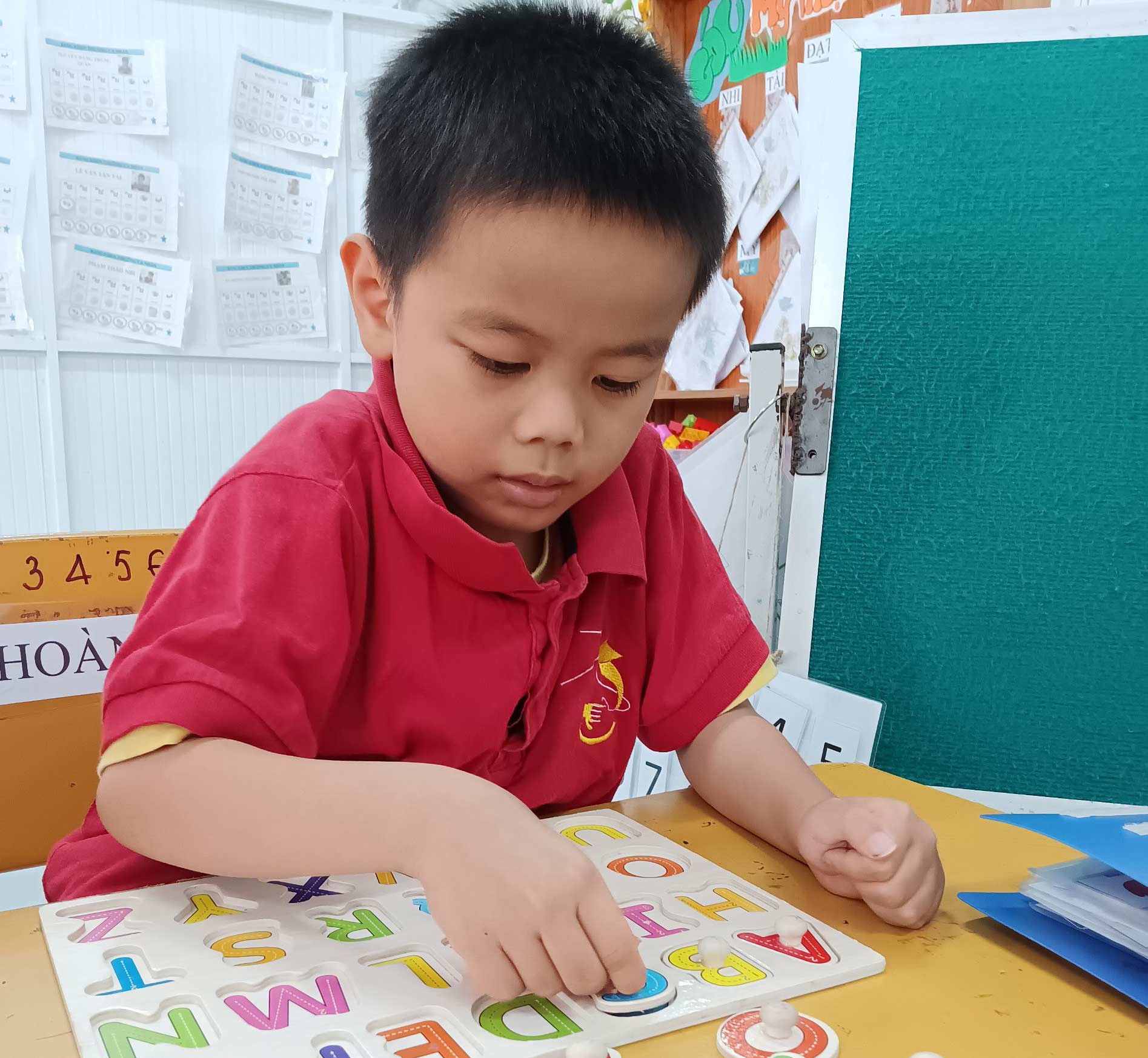 A boy plays a word game at Kianh Foundation Center, a school for children with special needs.