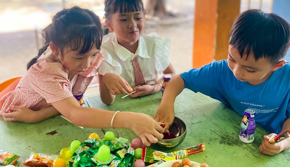 Children at a daycare in Vietnam eat snacks