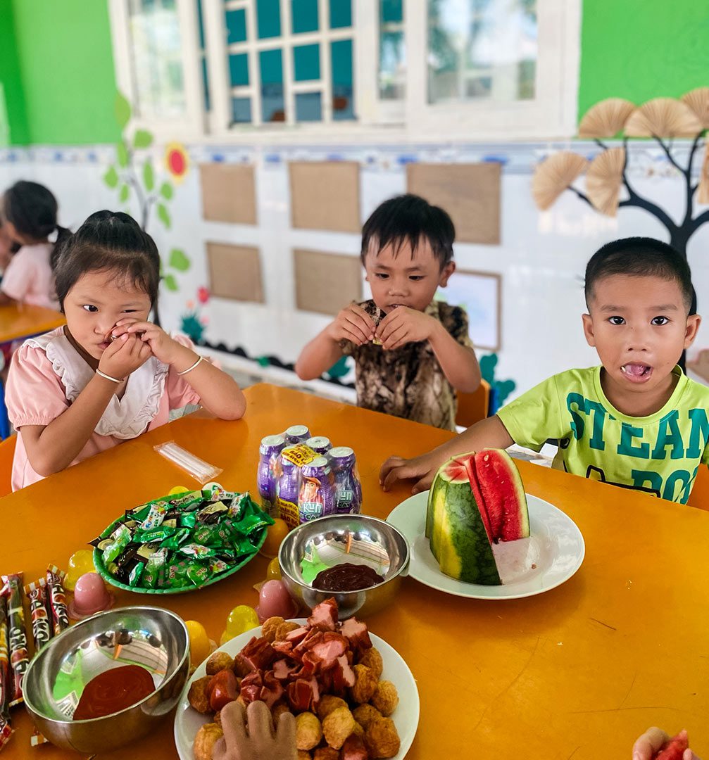 Children at a daycare in Vietnam eat snacks