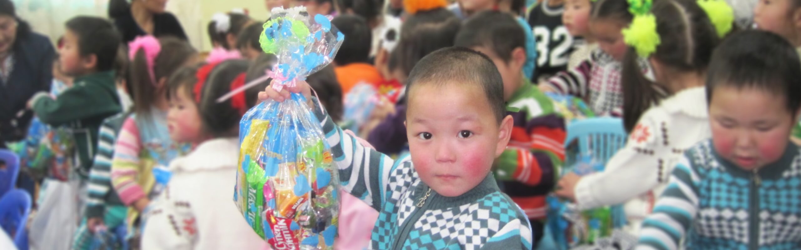 Group of children at a Christmas party holding their gifts