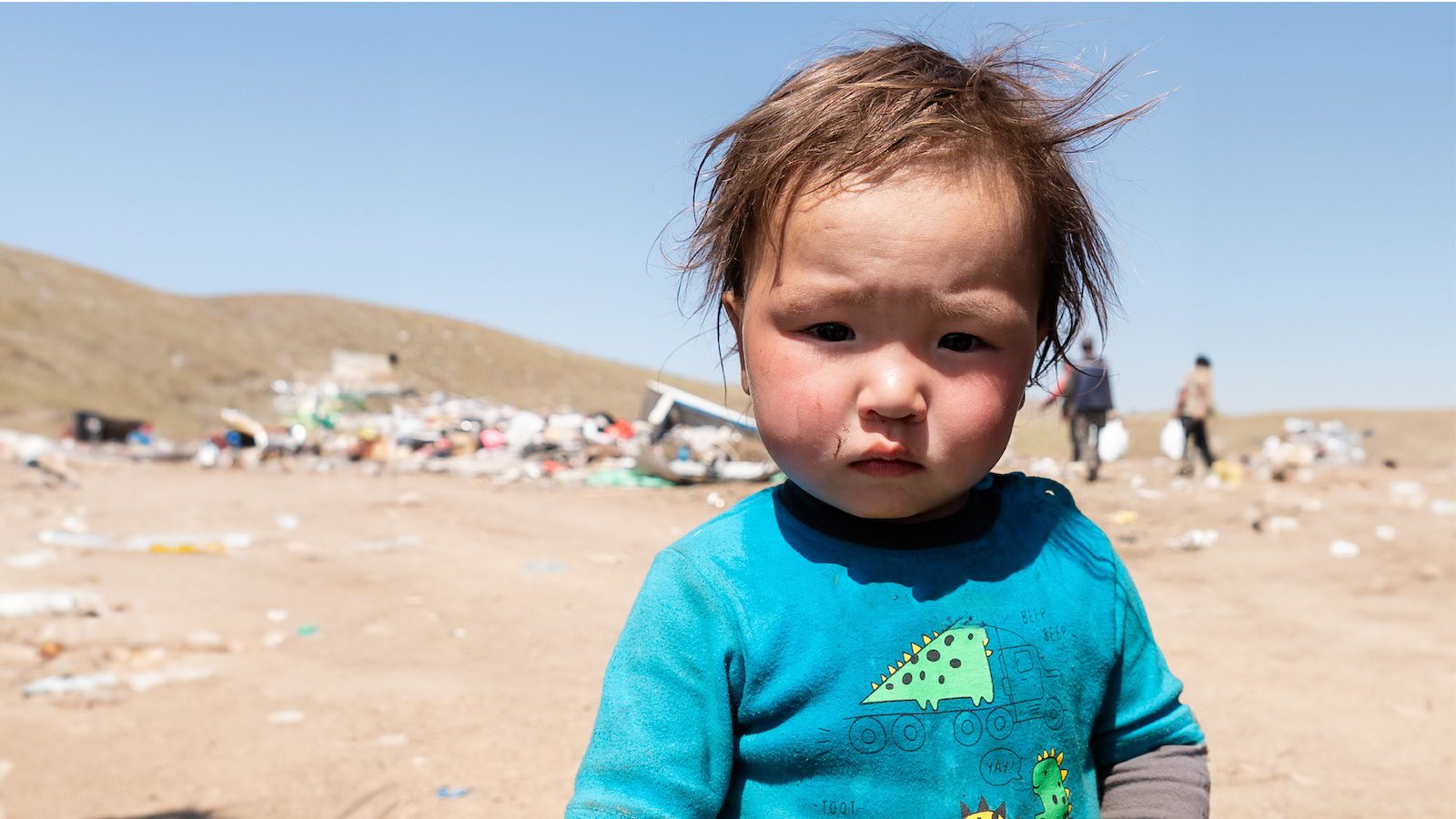 Young boy in Mongolia standing outside a garbage dump