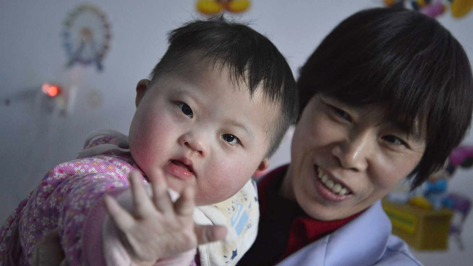 Child with Down syndrome with caregiver in China