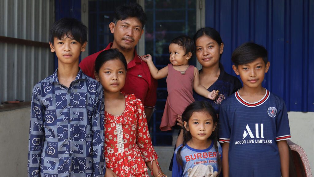 Large family standing together outside their home