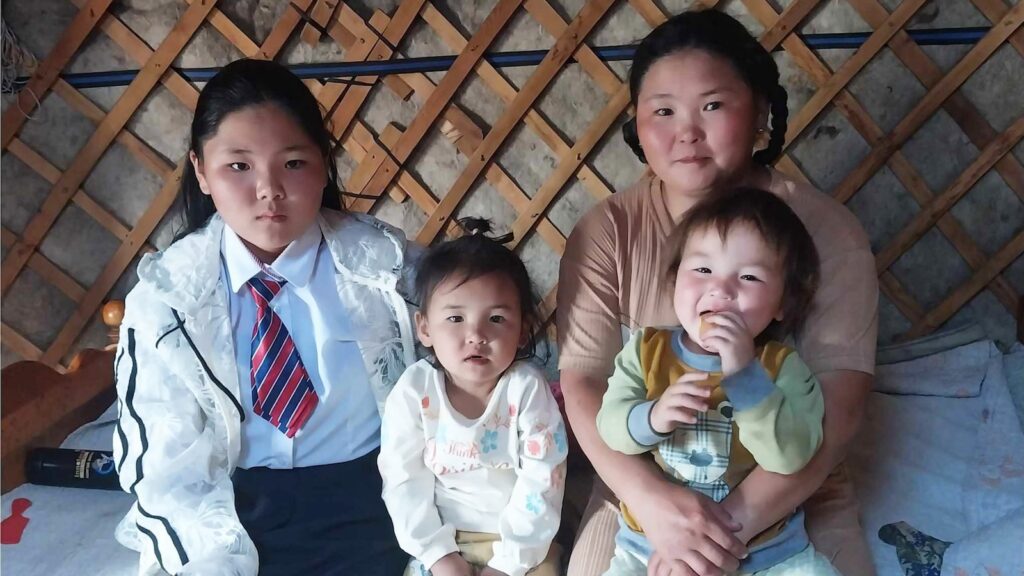 Mongolian family sitting inside their home