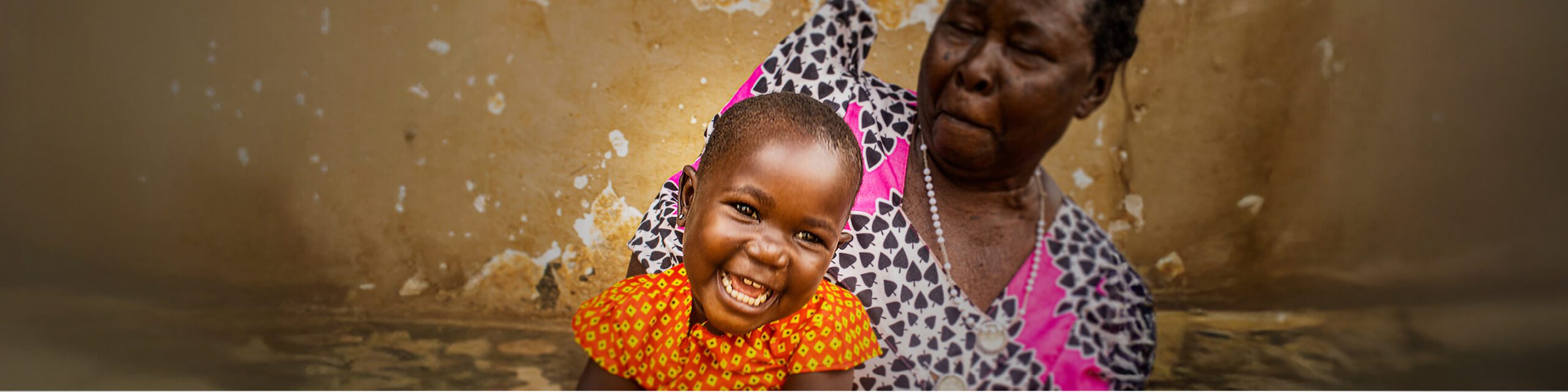 Achen, smiling, with her grandmother, after receiving food assistance in Uganda