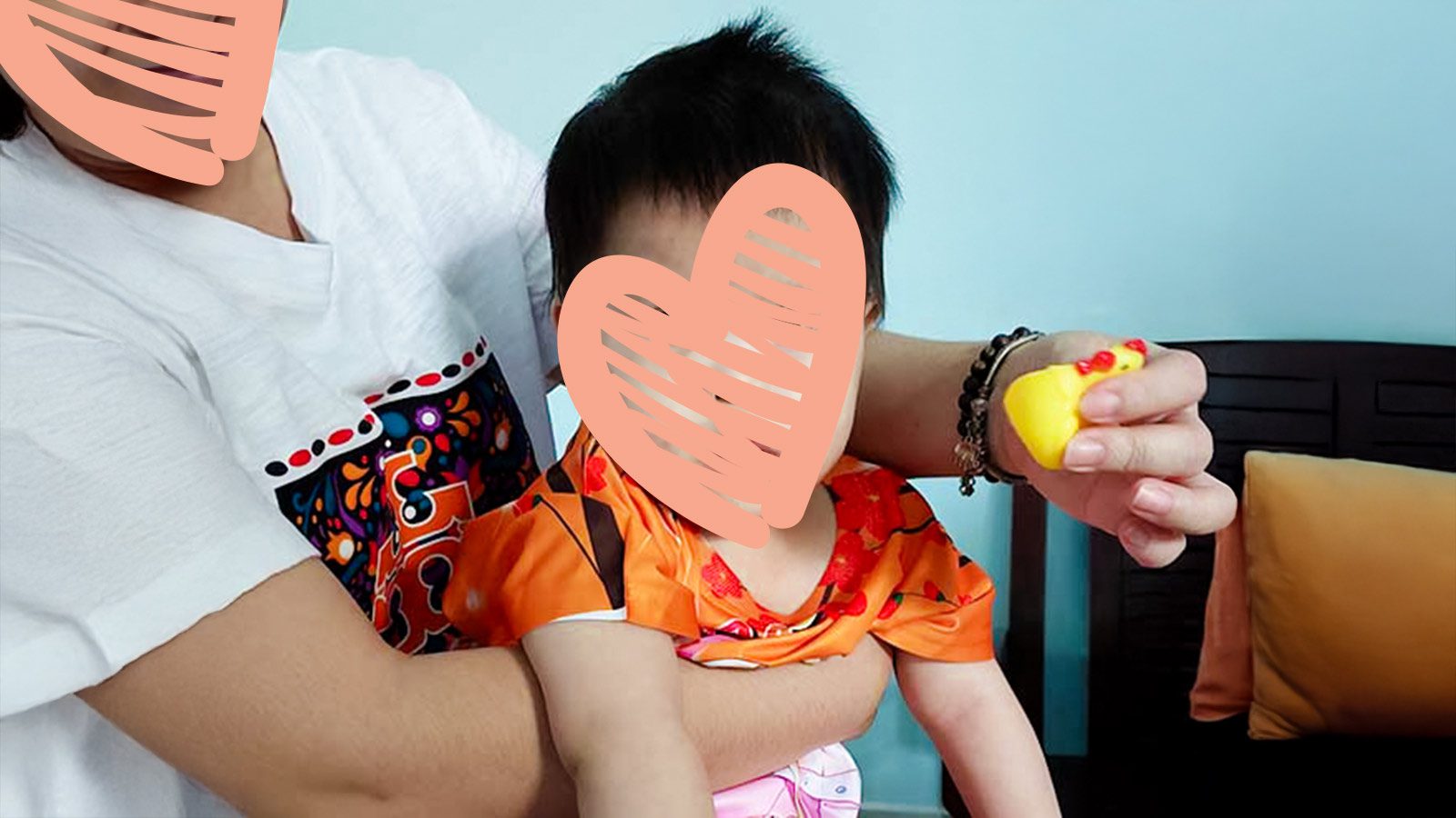 A caregiver holds a waiting child in her arms